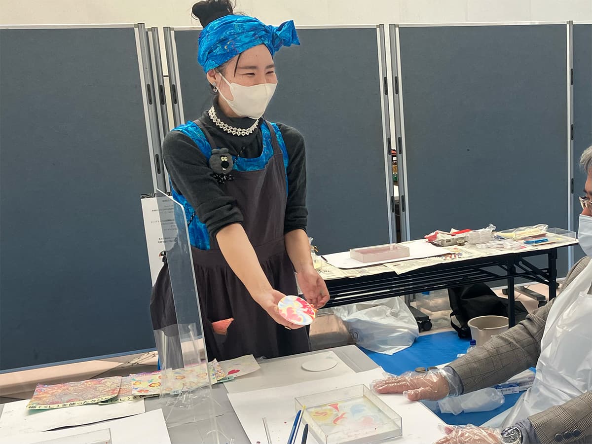 静岡県障害者芸術祭でのマーブリングアートワークショップのコースターを水面から引き上げた様子