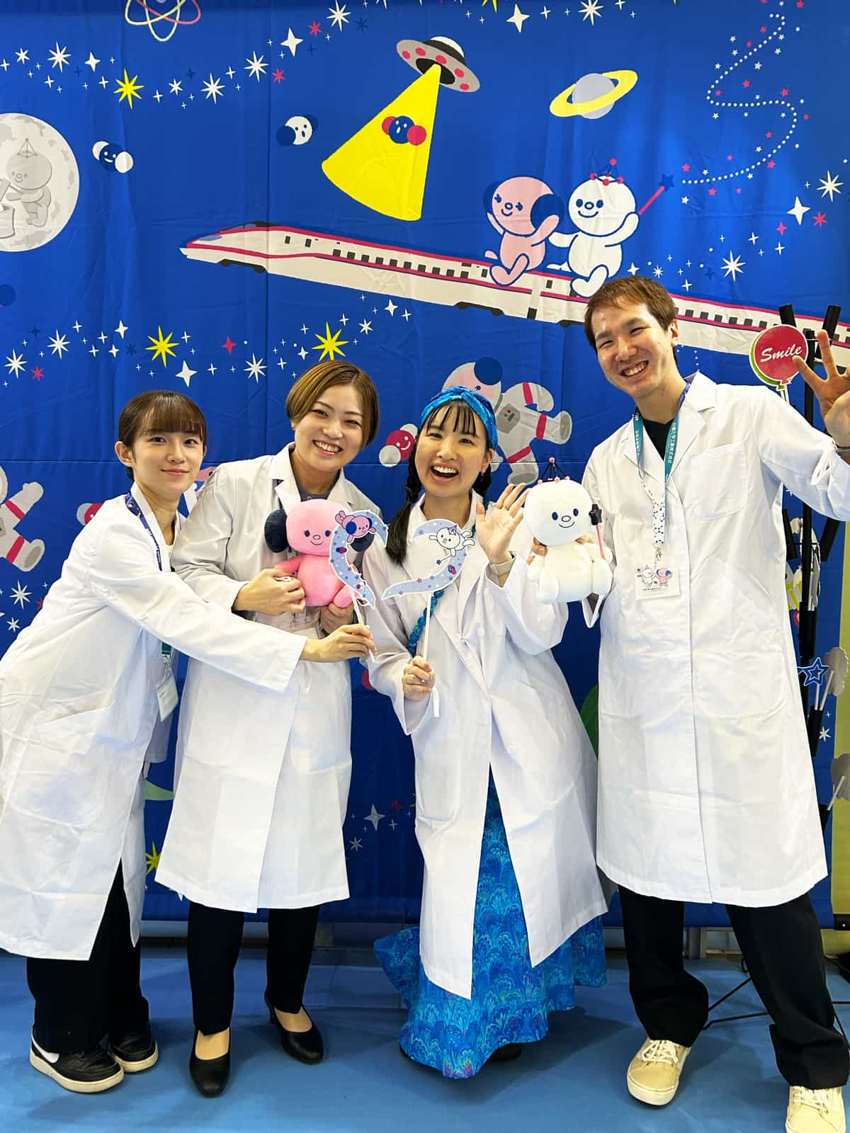 日信化学工業株式会社の白衣に袖を通すマーブリングアーティストらっくあまるも